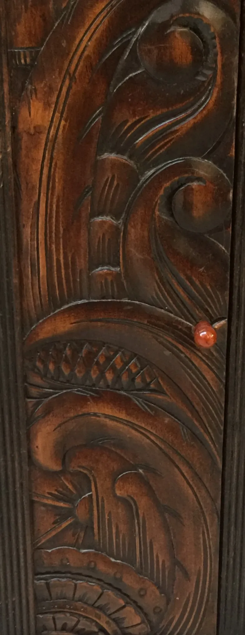 Escritorio antiguo con tallados decorativos en la madera, color oscuro.