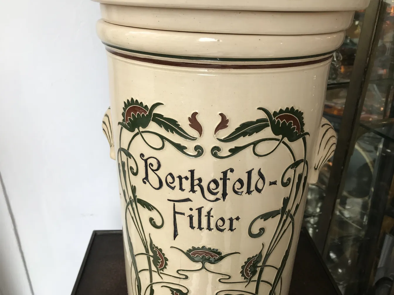 Antigua cerámica con diseño floral y texto Berkefeld-Filter.