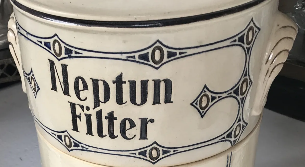 Ancient ceramic with blue design and Neptun Filter text