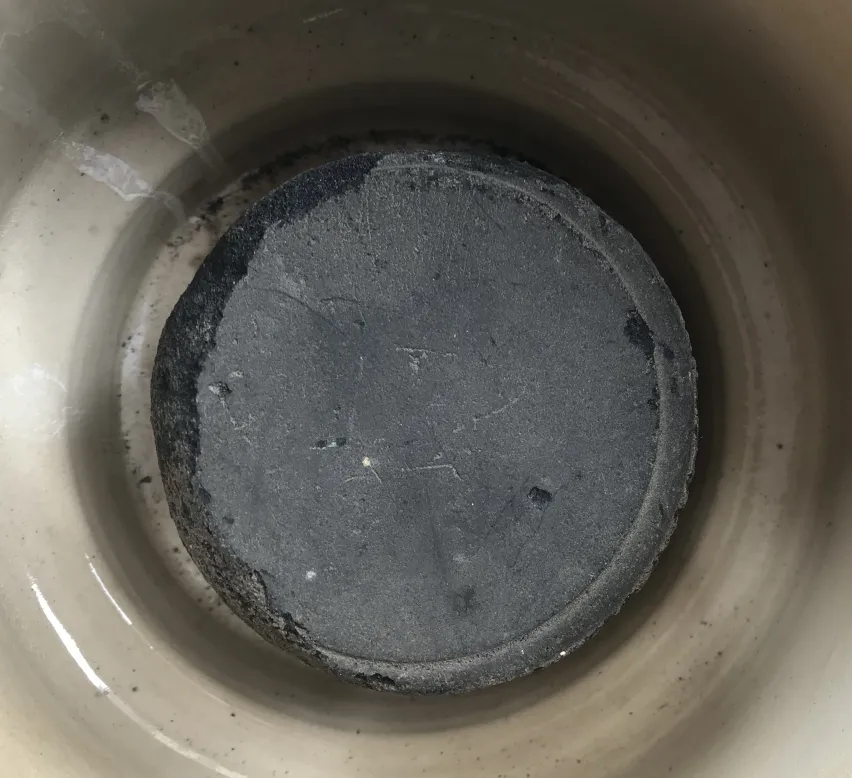 Base rotonda di ceramica antica in un ambiente semplice