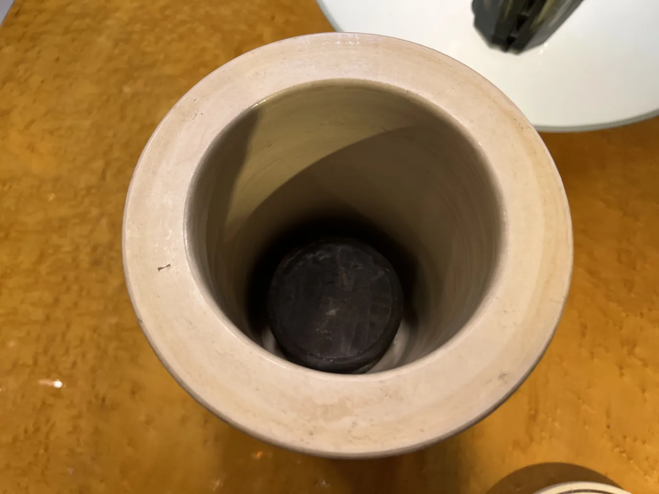 Luftaufnahme einer antiken Keramik mit kreisförmigem Inneren und dunklem Boden.