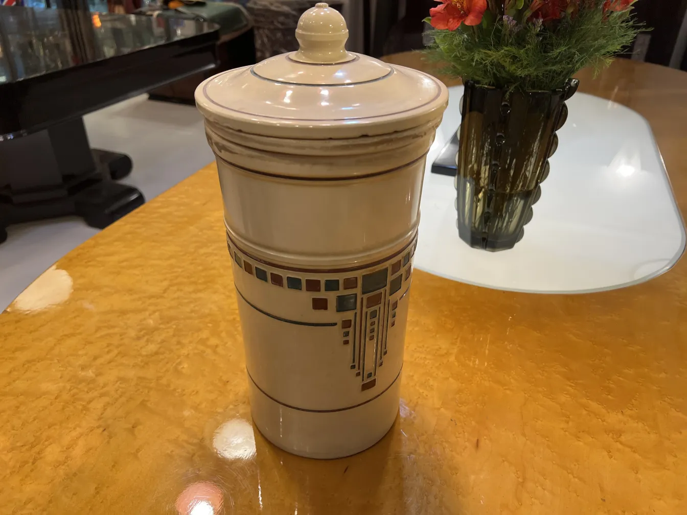 Antica ceramica decorativa di colore bianco con motivi sulla superficie, su un tavolo giallo.