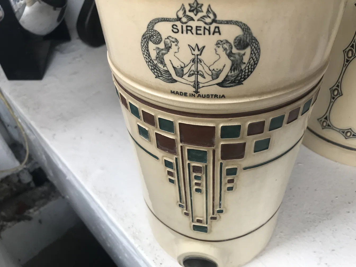 caneca de cerâmica antiga com design em tons claros