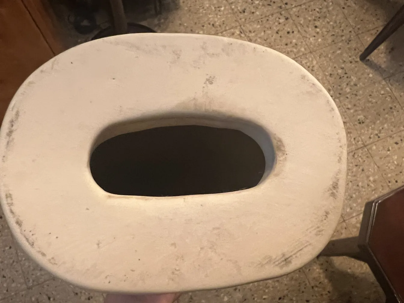 Cerámica antigua con un hueco ovalado en la parte superior.