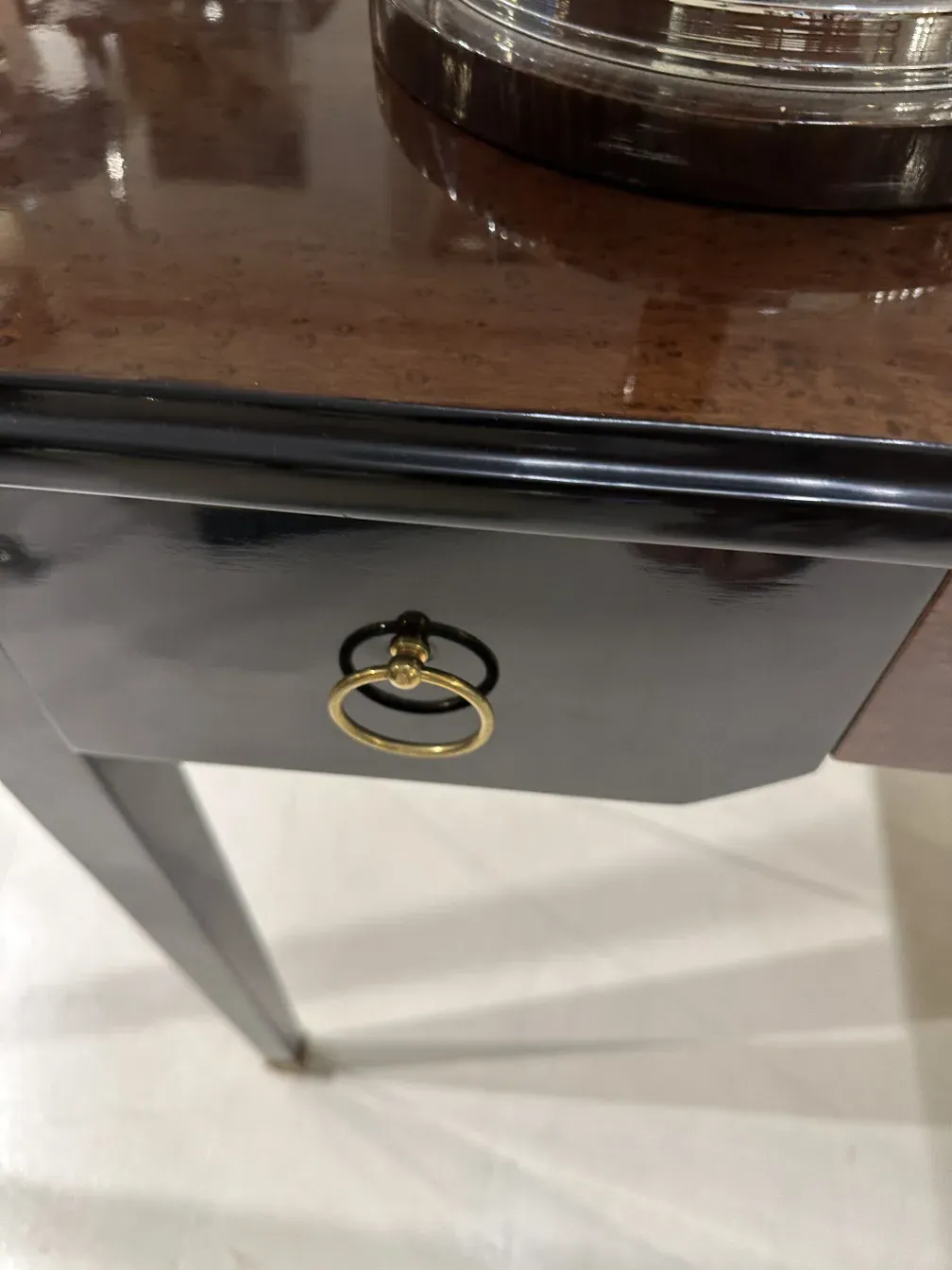 Antique desk featuring decorative gold trim and elegant handle.