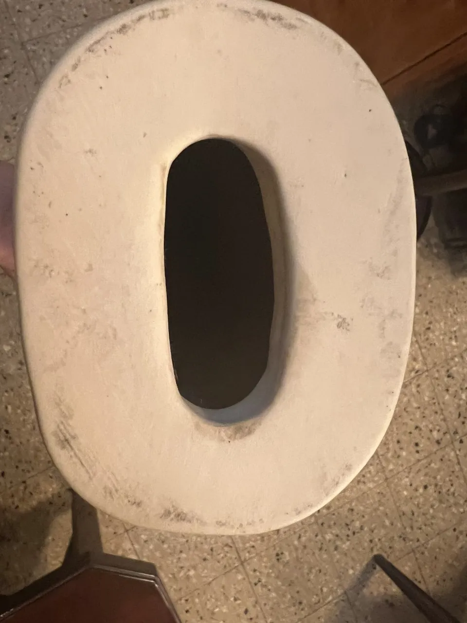 Escultura de cerámica antigua con forma ovalada y detalles sutiles.