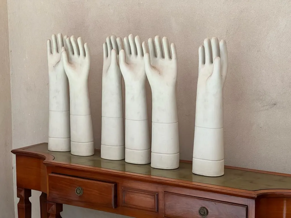 Conjunto de mãos decorativas de cerâmica antiga em um ambiente neutro.