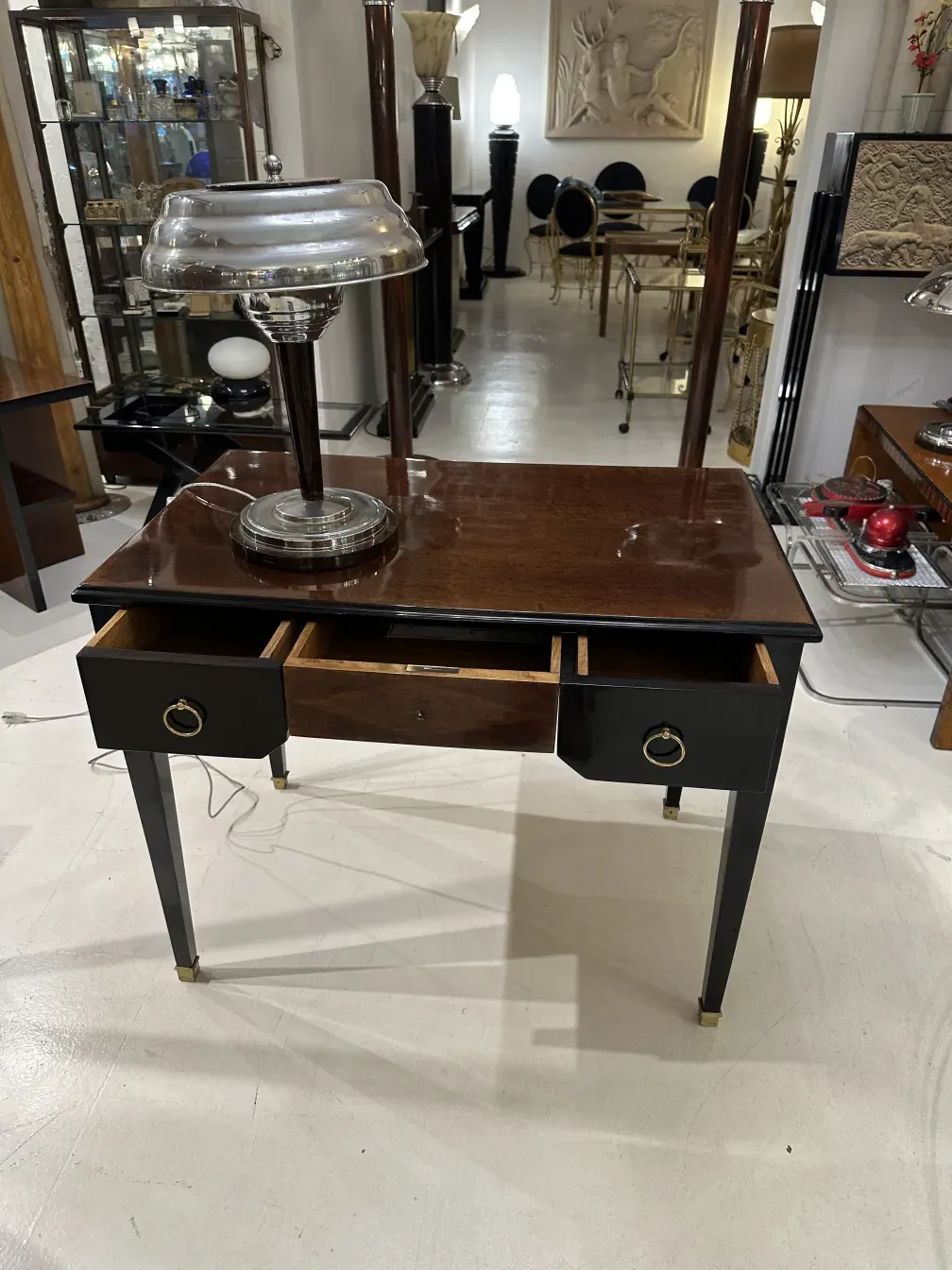 Bureau ancien en bois avec lampe et espace de rangement.