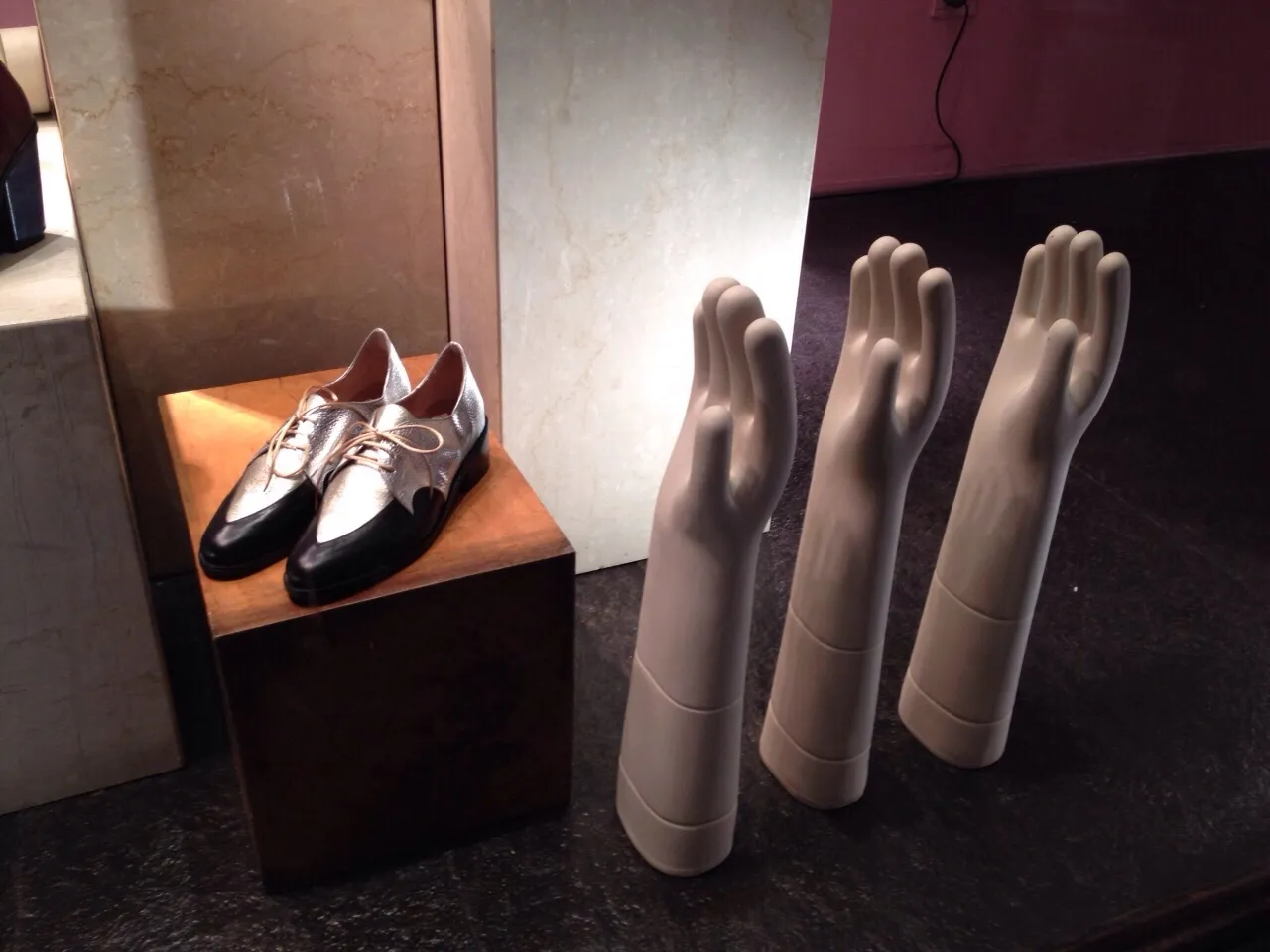 Affichage de mannequins de main et de chaussures, avec de la céramique ancienne en arrière-plan.