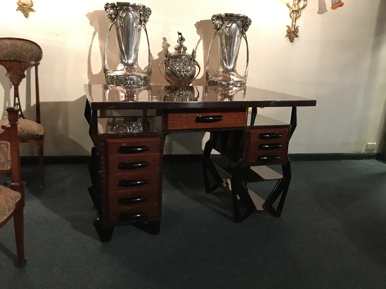 Bureau ancien avec des vases décoratifs dessus.