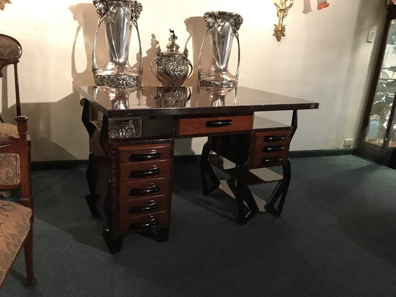 Bureau ancien élégant avec tiroirs et détails artistiques.