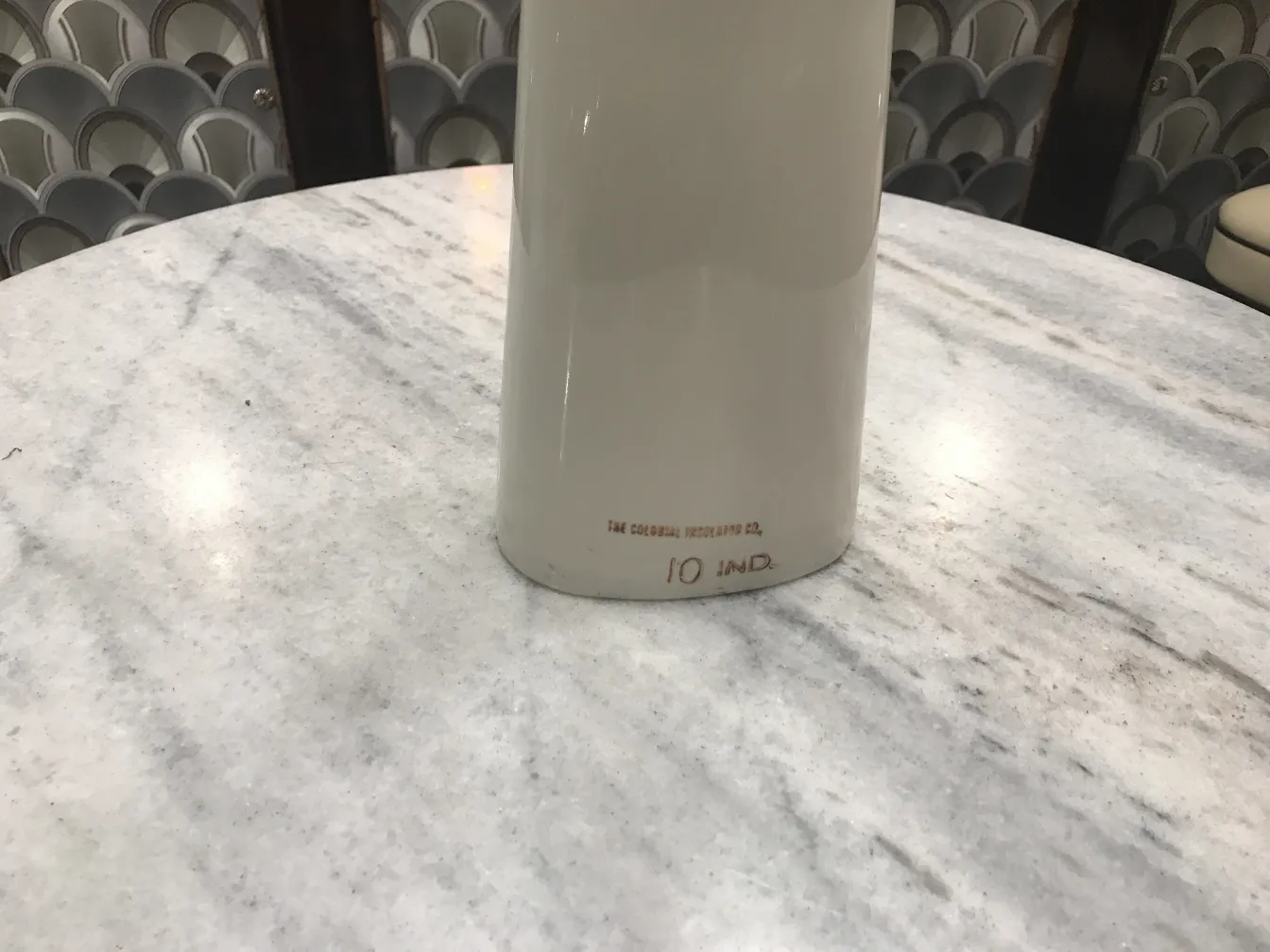 Ceramica antiga com detalhe de base visível, em fundo claro.