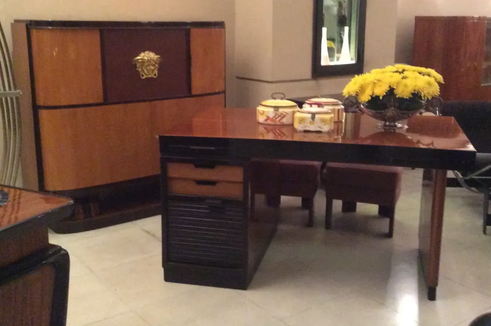 Scrivania antica con fiori gialli e accessori decorativi.