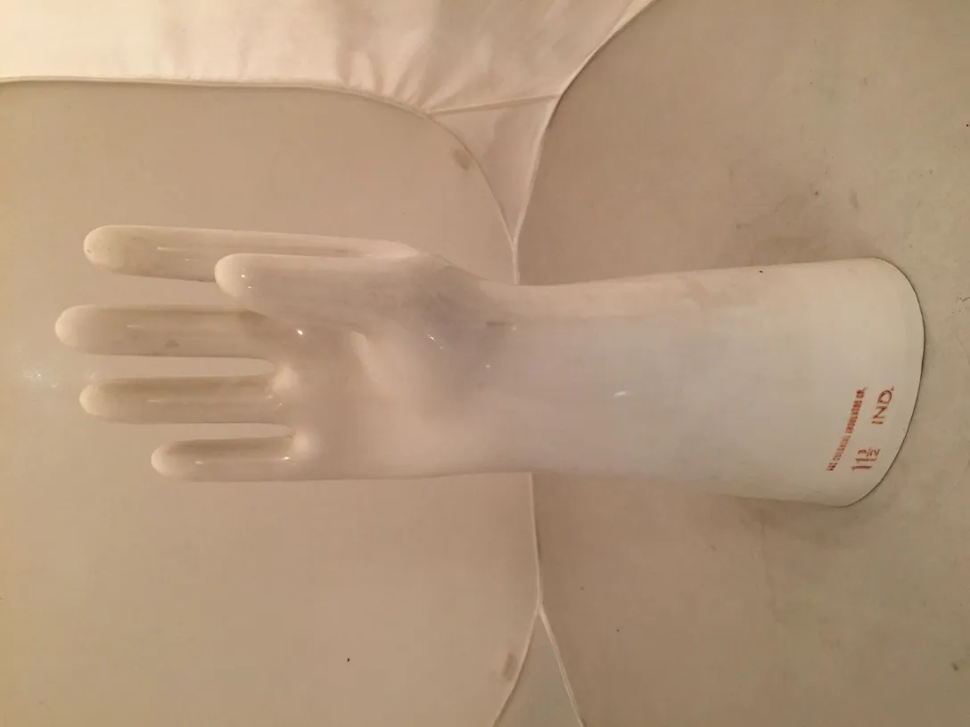 Antique ceramic in the shape of a decorative hand, white with simple details.