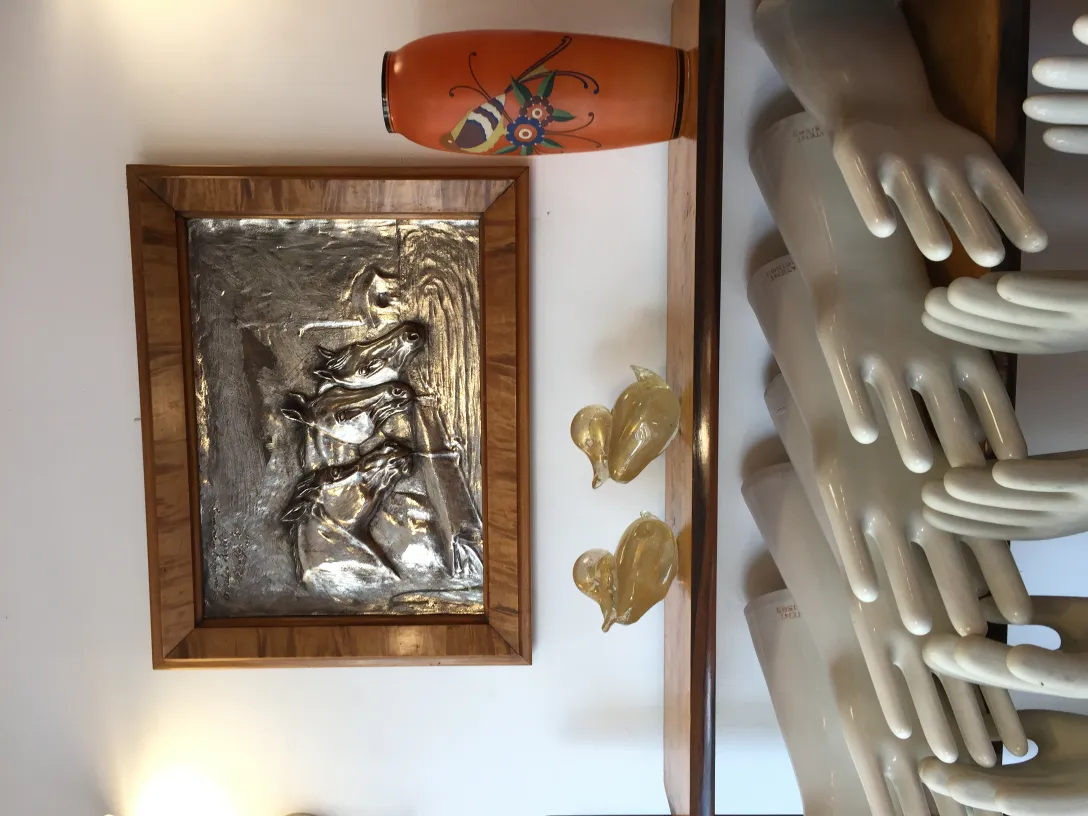 jarrón cerámico antiguo de color naranja decorado a mano, rodeado de figuras escultóricas