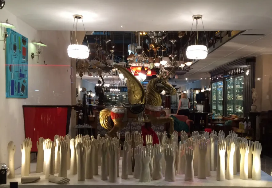 Vitrine mit antiken Keramikhänden und einem goldenen Pferd