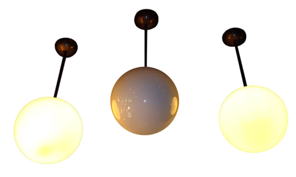 Five antique hanging lamps featuring spherical designs, enhancing a stylish setting.