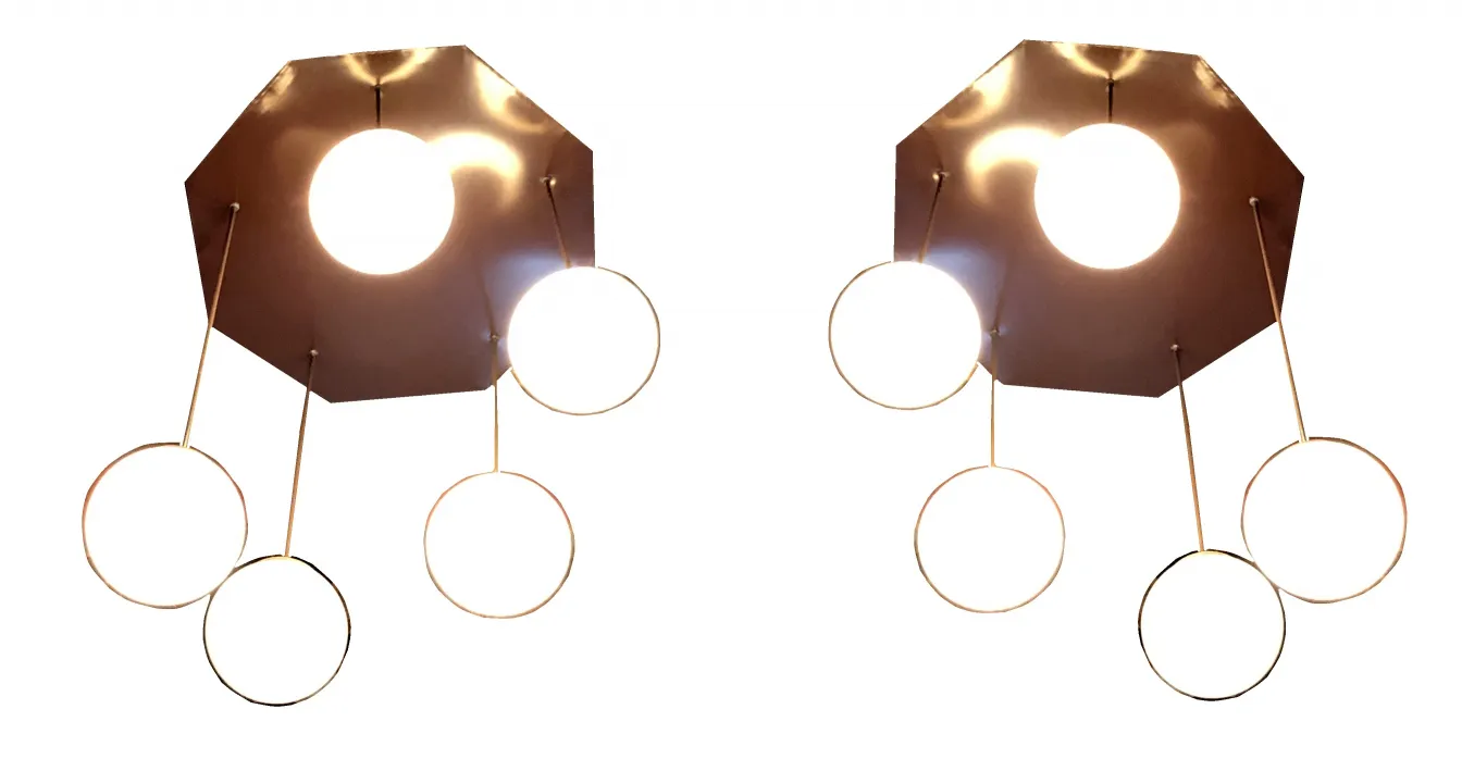 Four antique hanging lamps with circular design, illuminating a modern space.