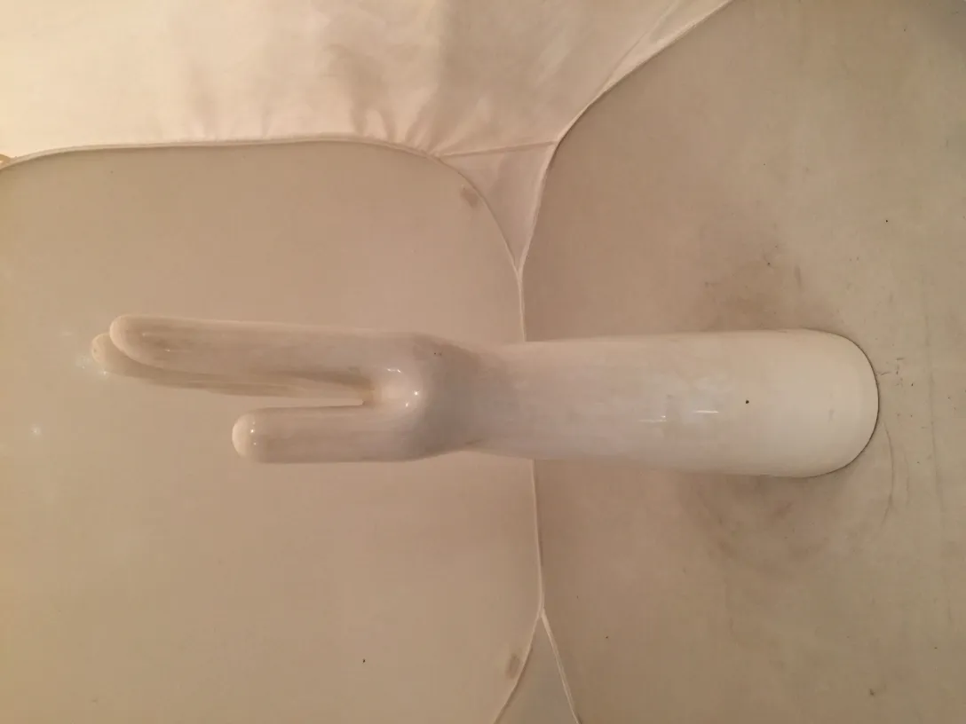 Antigua cerámica blanca en forma de mano con detalles únicos.