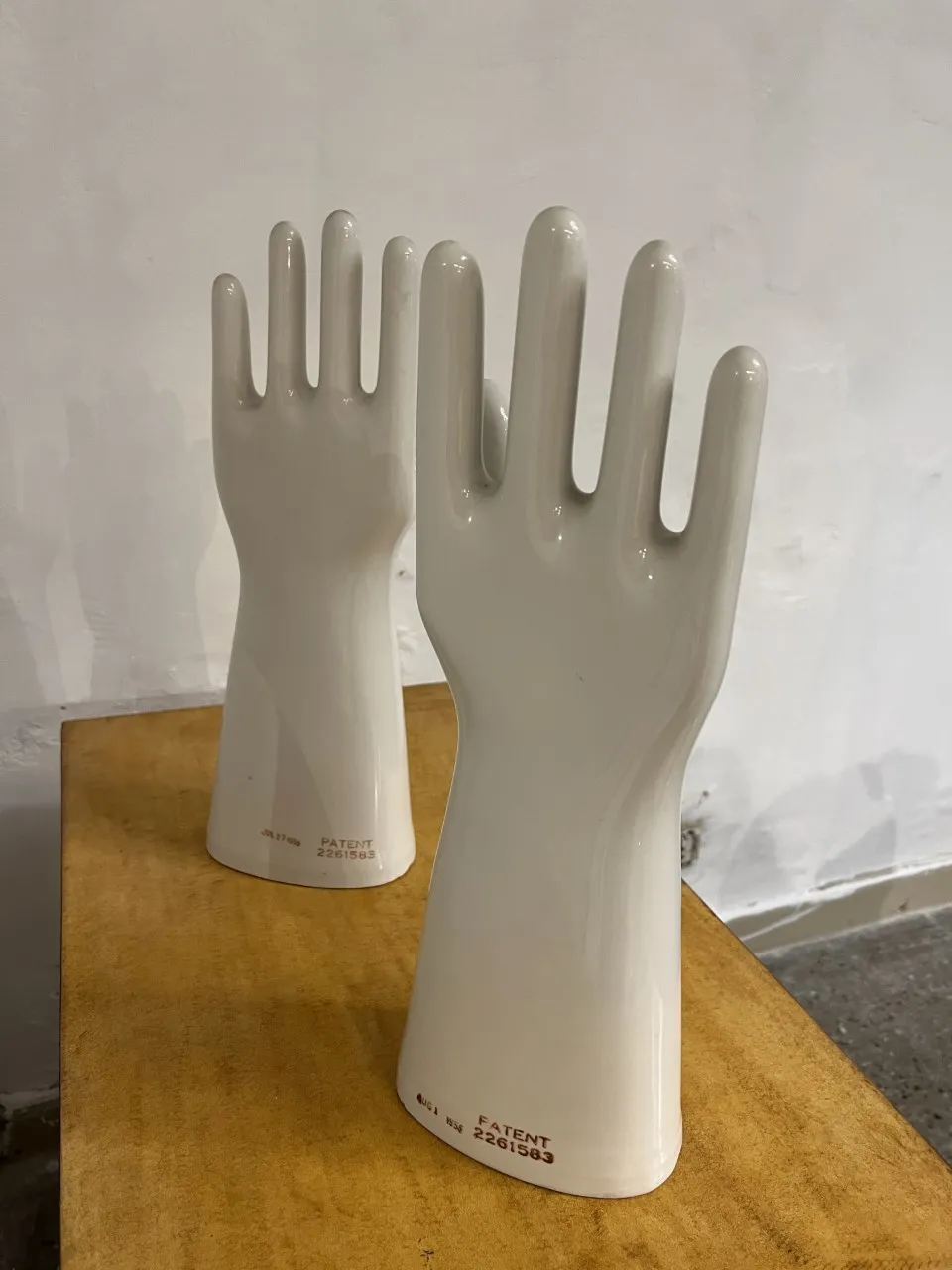 오래된 흰색 도자기 손이 나무 테이블 위에 있습니다.