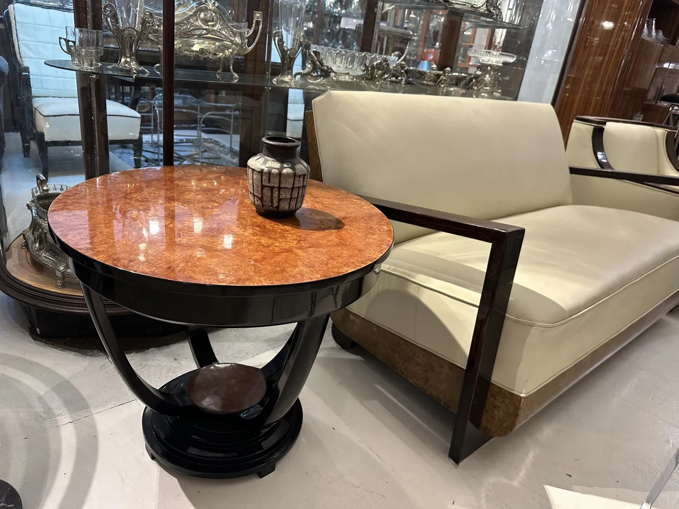 Jarrón de cerámica antigua sobre mesa decorativa con superficie brillante.