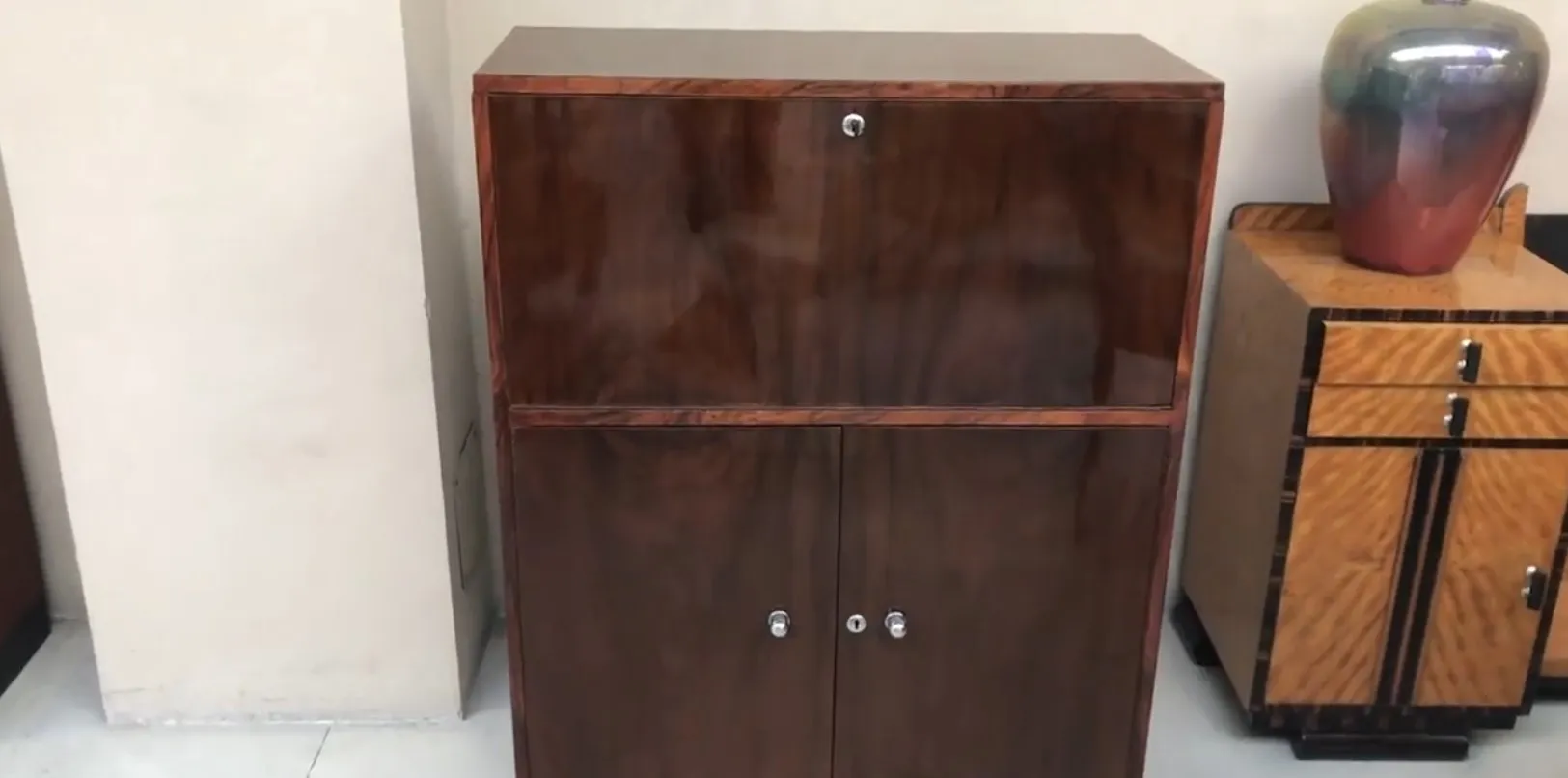 antique desk with compartments and smooth surface, surrounded by other furniture