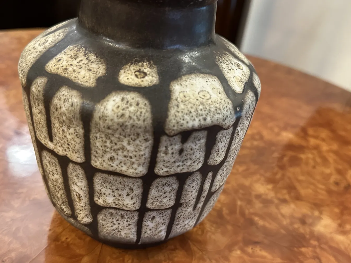 Antique ceramic vase with unique design in dark and light shades.