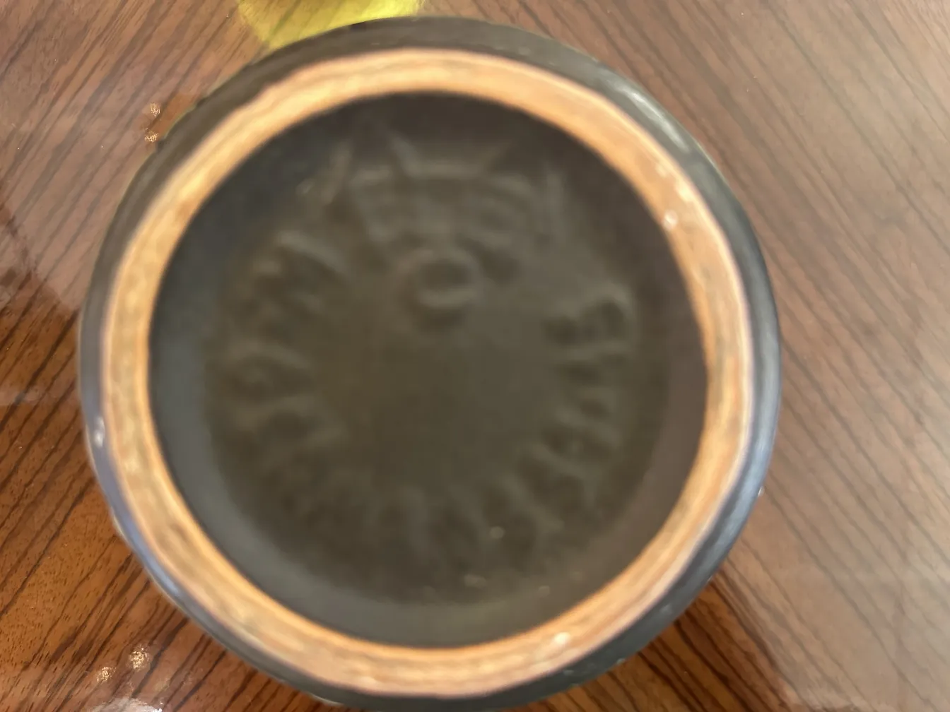 Visão da parte inferior de uma cerâmica antiga com detalhes artesanais.