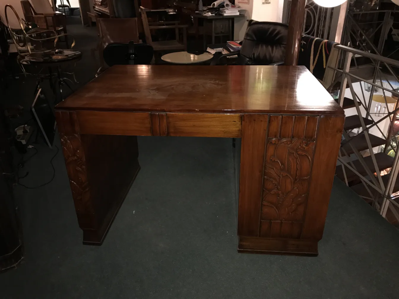 Bureau ancien en bois avec détails sculptés, dans un cadre d'exposition