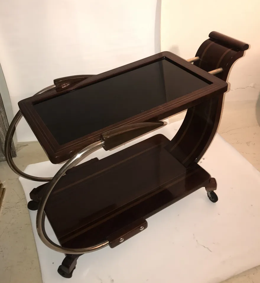 Mesa carrito antigua de madera con estante inferior y ruedas.