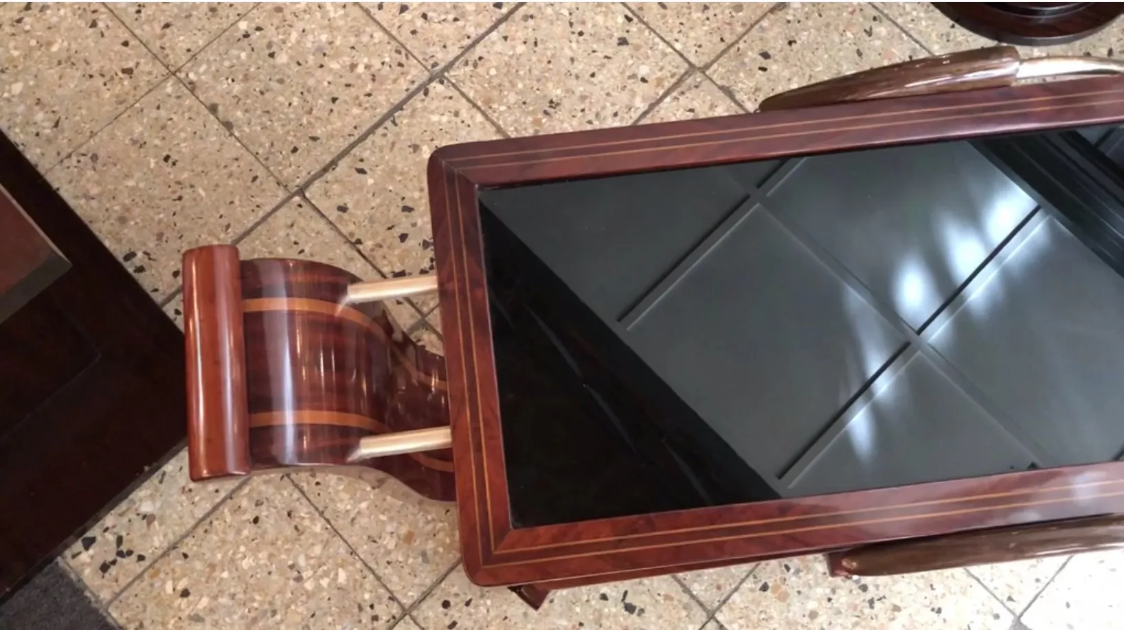 Mesa carrito antigua de madera con detalles decorativos.