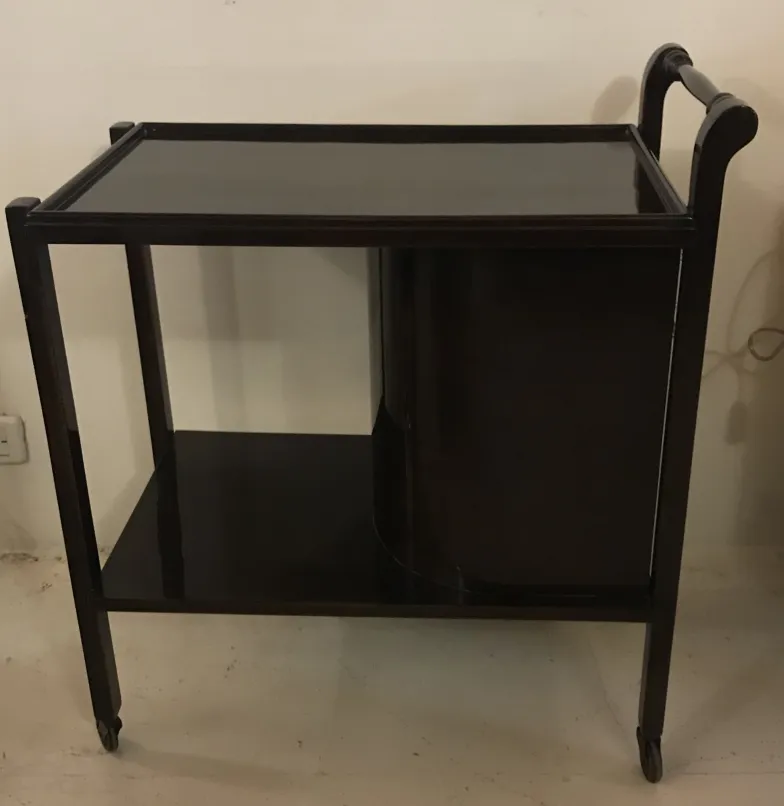 Старинная деревянная коктейльная тележка на колесах, элегантная и функциональная.