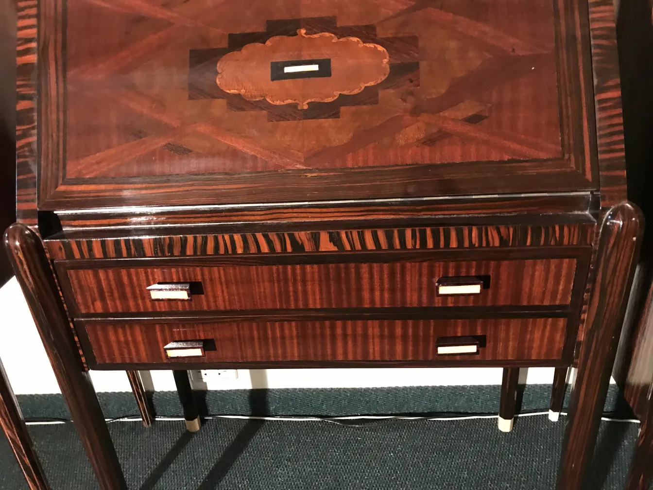 Escritorio antiguo con acabado brillante y detalles elegantes, dos cajones.