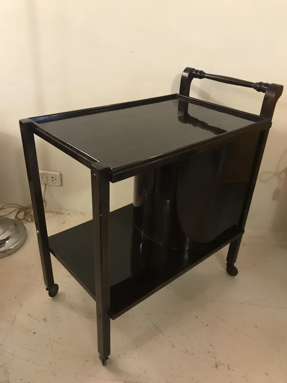 Античная тележка для коктейлей с двумя уровнями, темное дерево, элегантный дизайн, нейтральный фон.