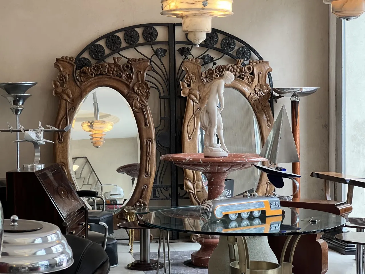 Antique desk surrounded by decorative elements such as mirrors and sculptures.