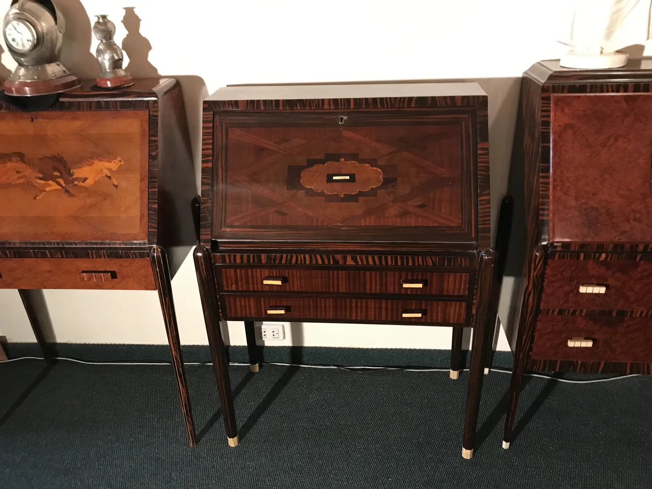 Antique desk with artisanal design details, surrounded by other furniture