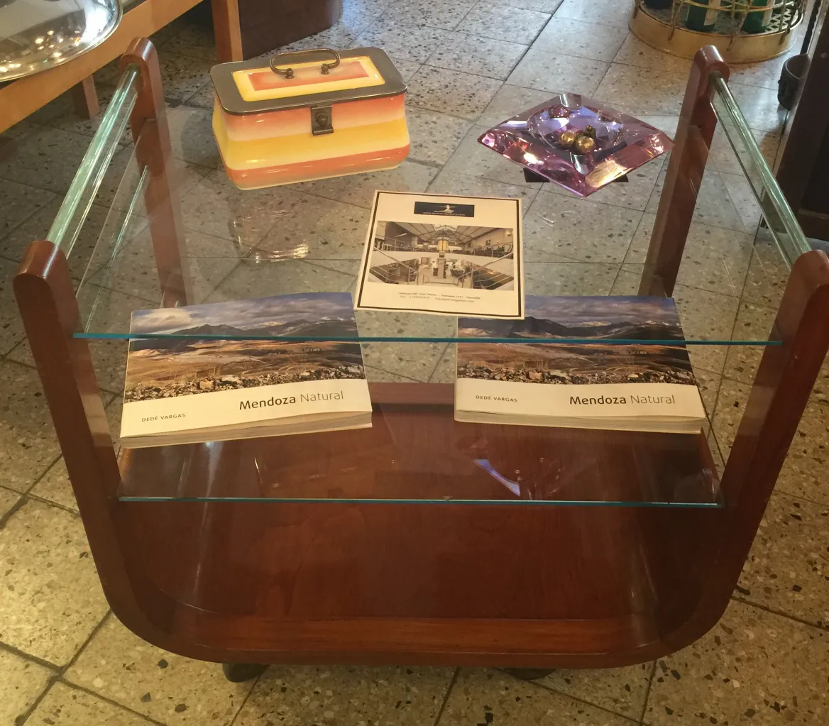 Mesa carrito antigua de madera con estantes de vidrio.