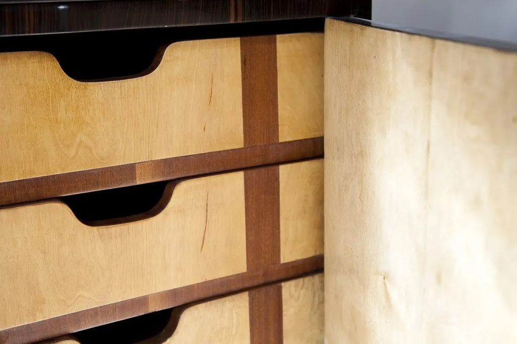 Scrivania antica in legno con cassetti visibili in dettaglio.