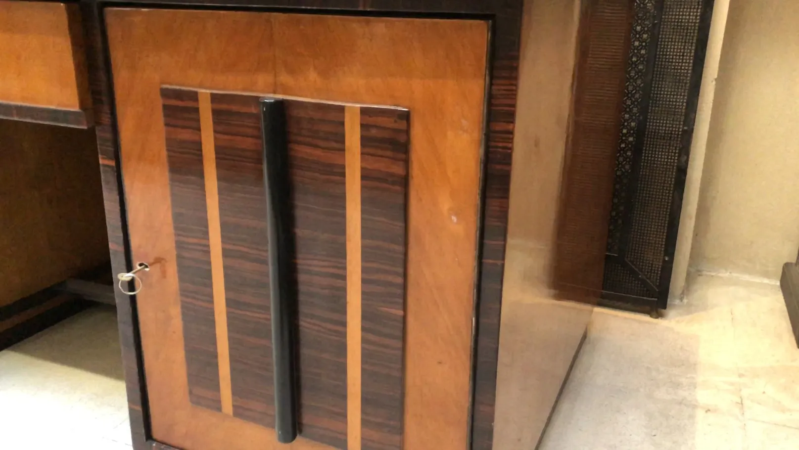 escritorio antigo com puxadores decorativos e acabamentos polidos em um ambiente elegante