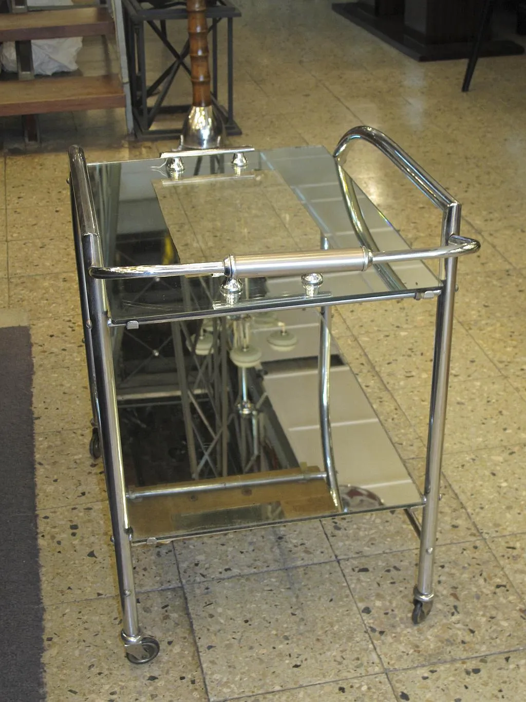 Carrello per cocktail antico con struttura in metallo e ripiani in vetro.