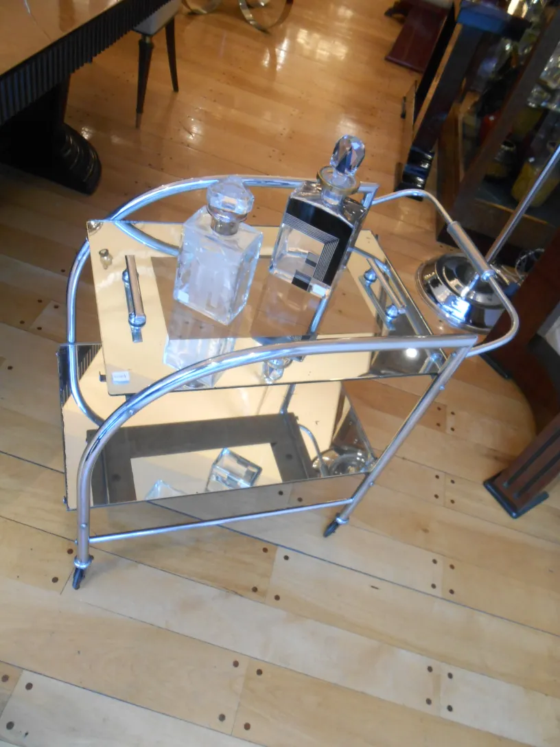 Antique cocktail trolley with mirrored surface and crystal bottles.