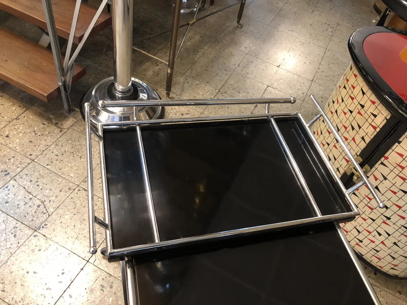 Mesa carrito antigua negra con estructura metálica, en ambiente acogedor.