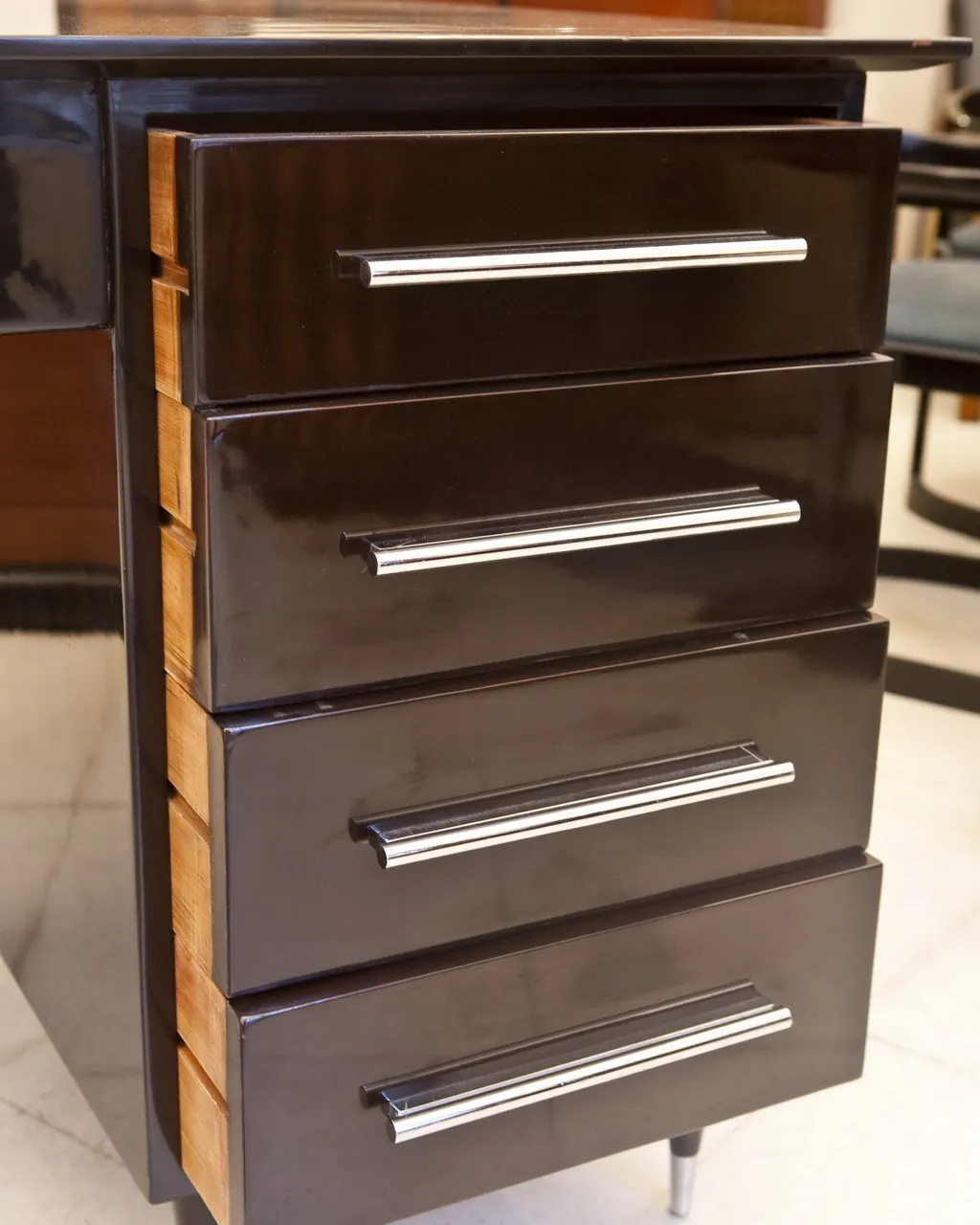 antique desk with black and light wood finish, four drawers, elegant setting