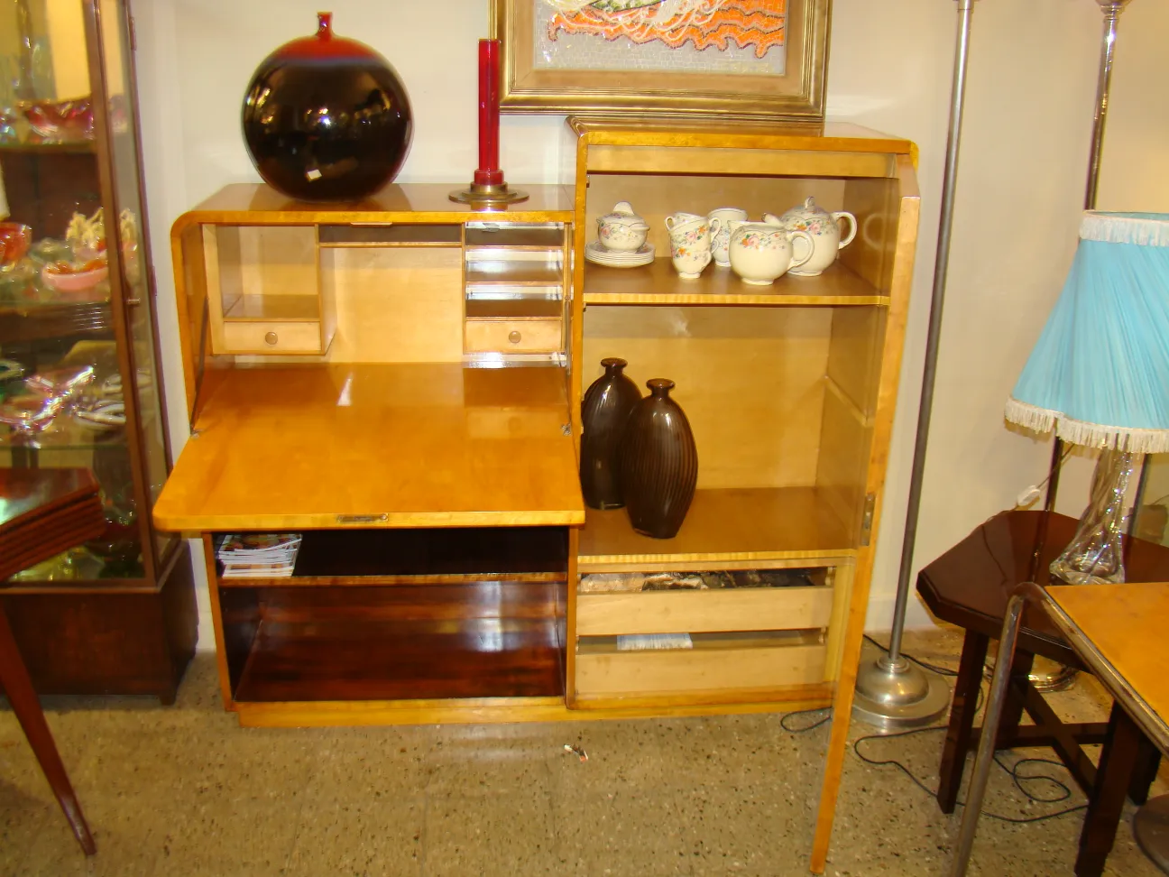 Bureau en bois ancien avec espace de rangement, près d'objets décoratifs.