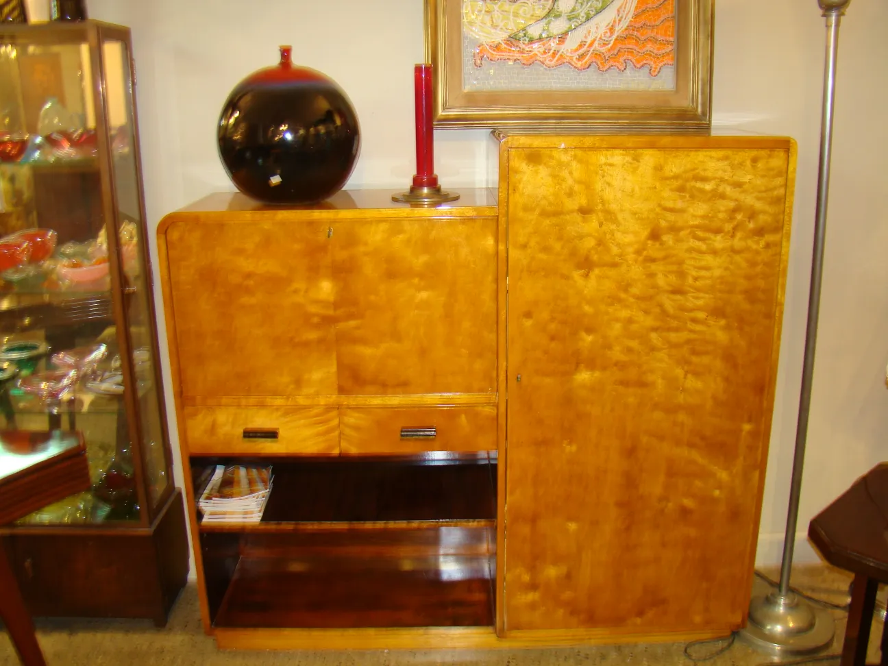 Escritorio antiguo de madera con estante, decorado con una lámpara.