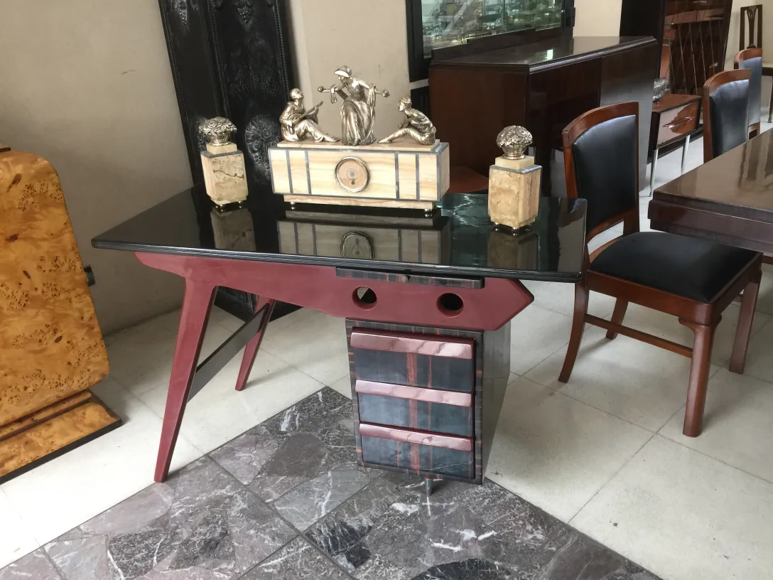 Antiker Schreibtisch mit einer eleganten schwarzen Oberfläche und stylischen Beinen, dekoriert mit dekorativen Stücke.