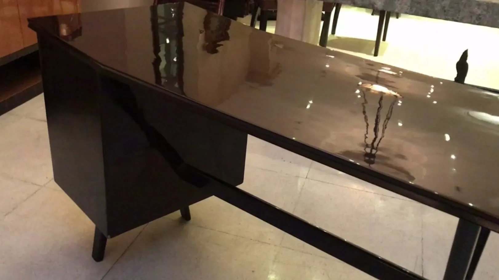 Scrivania nera antica con finitura lucida in un ambiente moderno.