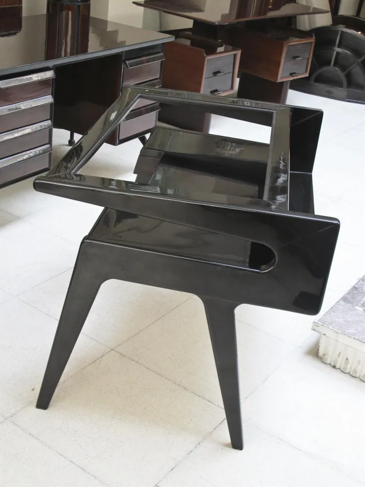 Scrivania antica nera lucida con design unico in un ambiente elegante.