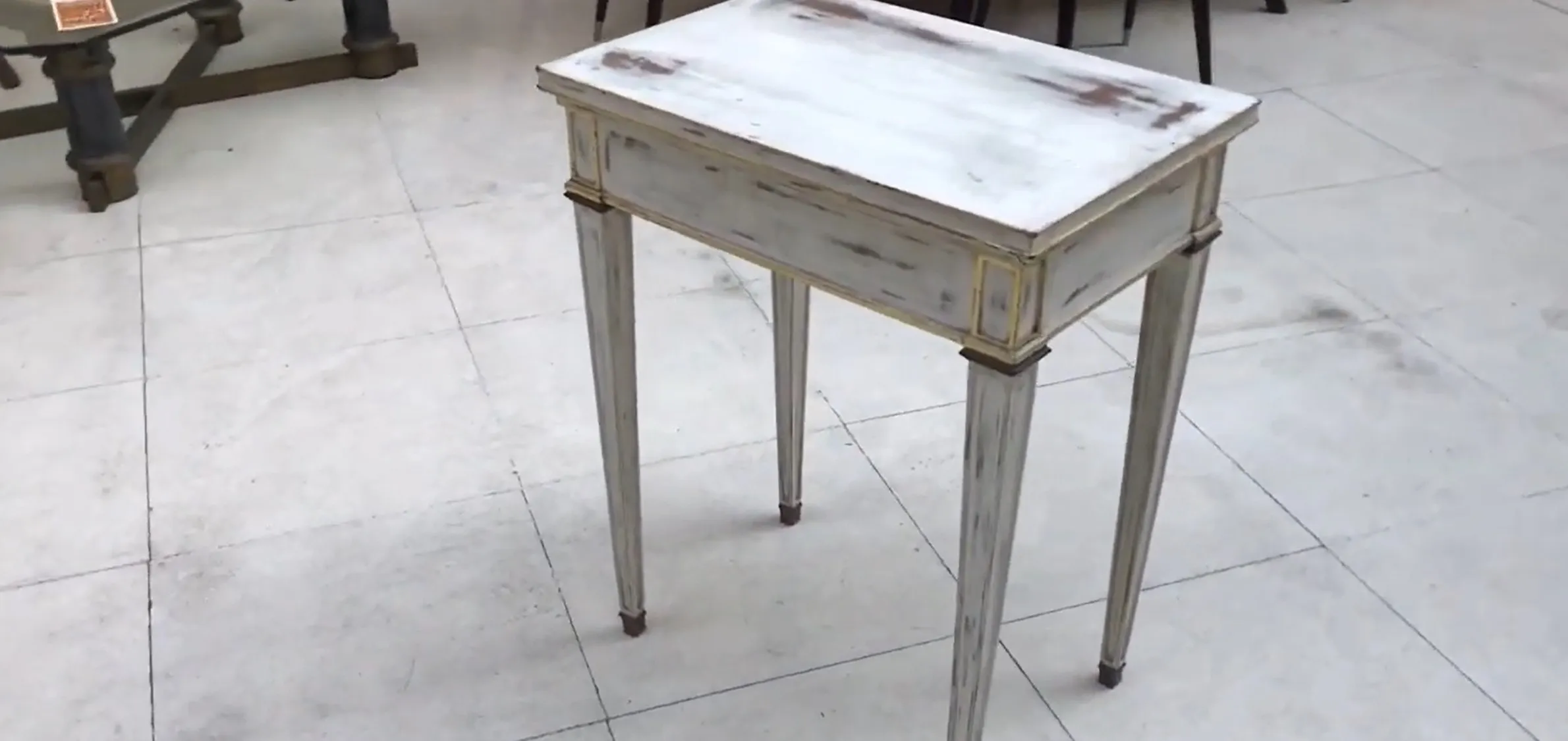 Antique white desk with slender, simple legs.