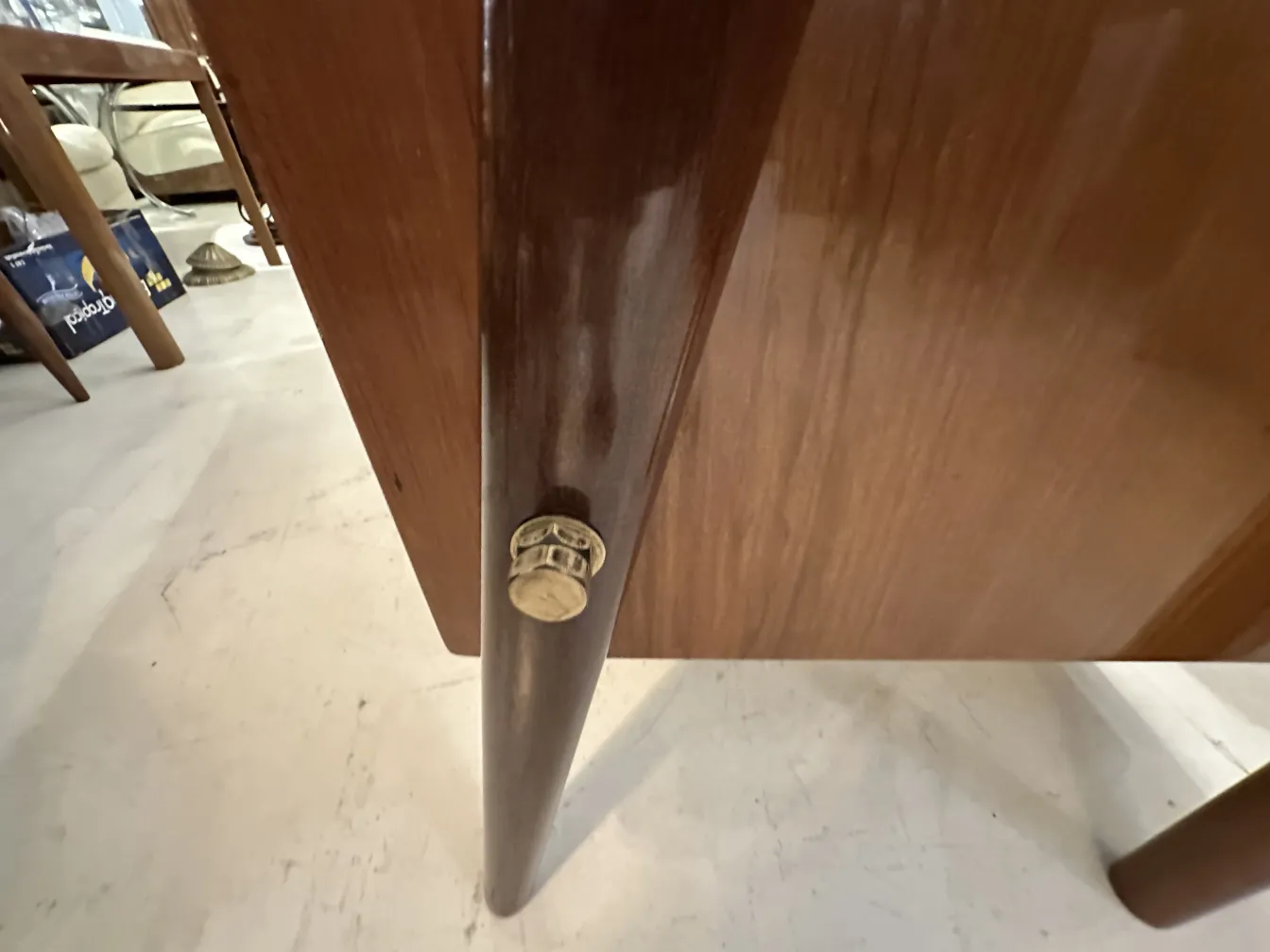 Vista della gamba di una scrivania antica con finitura in legno e accessori.